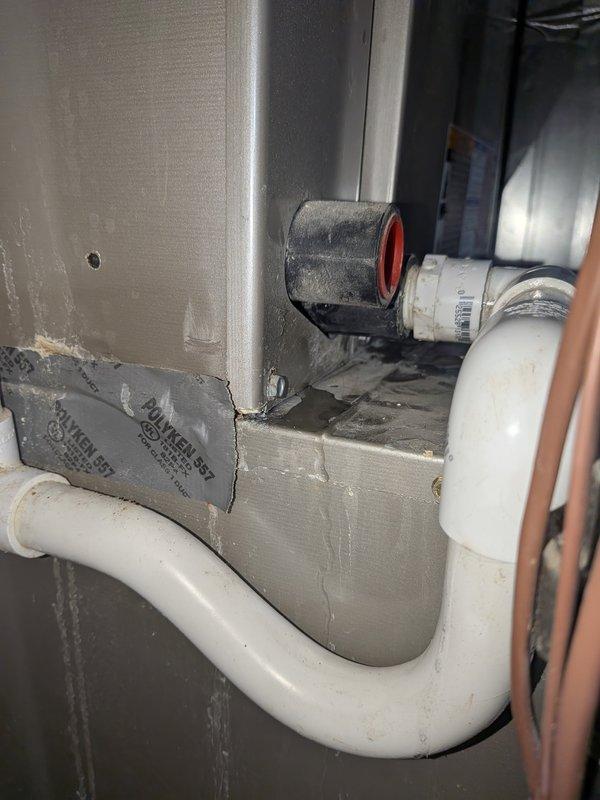 Responded to service call for air conditioning unit experiencing water leakage onto floor. Upon inspection, discovered condensate drain line obstruction and significant corrosion on humidifier solenoid valve assembly. Cleared clogged PVC condensate drain line to restore proper drainage from evaporator coil. Assessed heavily corroded humidifier valve and connecting components, which customer had previously shut off due to deterioration. Documented existing corrosion damage on valve body and mounting hardware for customer records. Verified condensate system now draining properly and provided recommendations for humidifier valve replacement to prevent future water leak issues.