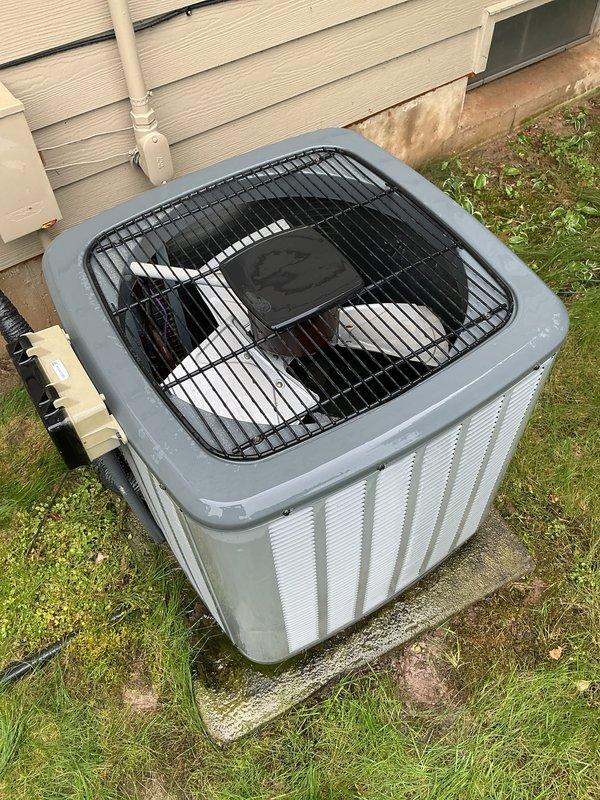 Completed annual AC tune-up on 11-year-old EnergiAir system with 2017 condenser model. During inspection, discovered severe ice buildup on refrigerant line indicating low refrigerant charge or restricted airflow. Documented ice accumulation on copper suction line with photographic evidence. Verified outdoor condenser unit operational with proper clearances and secure mounting on concrete pad. System requires follow-up for refrigerant leak detection and charging, as ice formation on suction line confirms inadequate cooling capacity and potential compressor damage risk if left unaddressed.