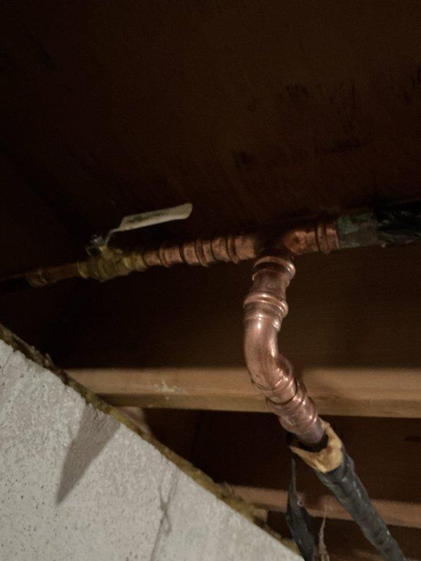 Responded to exterior faucet leak causing water infiltration into basement. Upon inspection, located copper supply piping in overhead space serving outside hose bib. Identified failed connection at pipe joint allowing water to leak through ceiling structure when faucet was operated. Repaired copper piping connection, secured all pipe sections to structural joists, and verified proper insulation placement on exposed water lines to prevent future freeze damage. Tested system under full pressure to confirm leak elimination and proper water flow to exterior faucet.