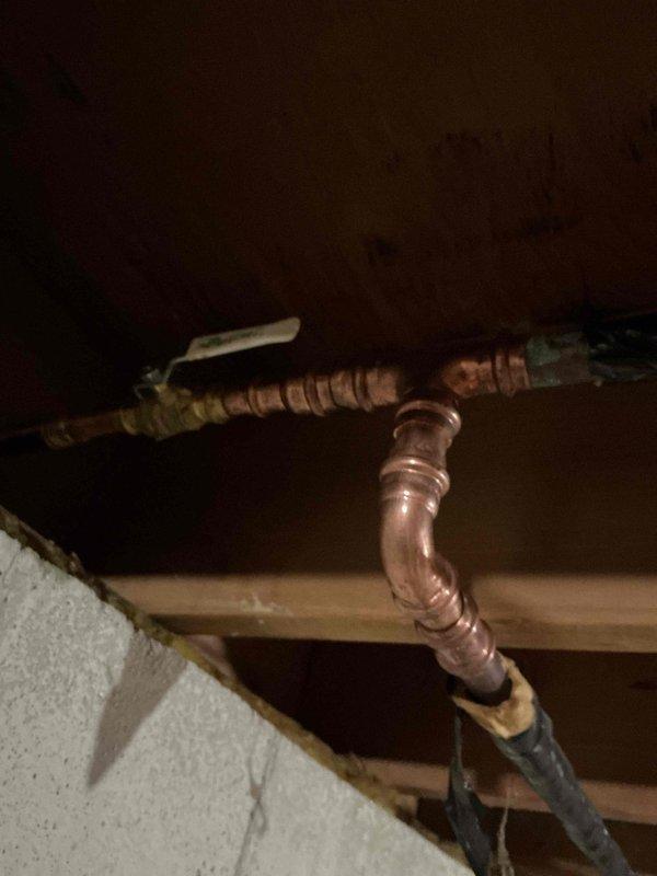 Responded to exterior faucet leak causing water infiltration into basement. Upon inspection, located copper supply piping in overhead space serving outside hose bib. Identified failed connection at pipe joint allowing water to leak through ceiling structure when faucet was operated. Repaired copper piping connection, secured all pipe sections to structural joists, and verified proper insulation placement on exposed water lines to prevent future freeze damage. Tested system under full pressure to confirm leak elimination and proper water flow to exterior faucet.