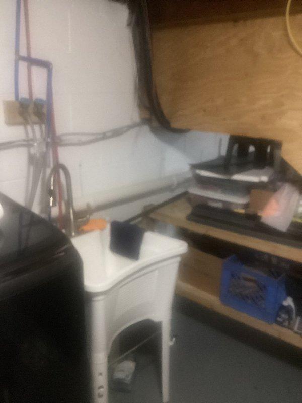 Completed kitchen drain line reroute across basement, running new drainage piping horizontally along foundation wall and tying into existing main stack. Installation included proper pitch and secure mounting with brackets to ensure code-compliant drainage flow from kitchen fixtures to the main waste line.