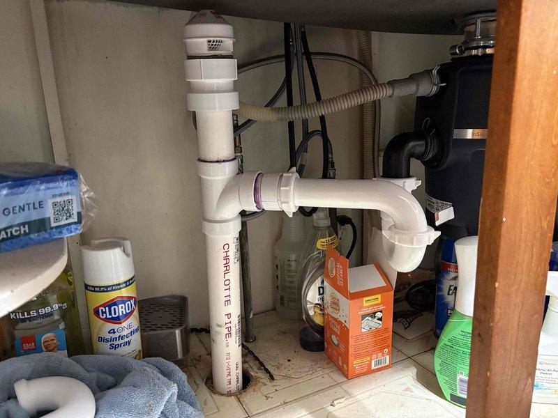 Returned to complete proper repair and upgrade of previous plumbing work performed on kitchen sink drainage system. Inspected under-sink plumbing configuration including P-trap assembly, garbage disposal connections, and drain lines to ensure all components meet code requirements. Verified proper water flow and tested for leaks at all connection points to confirm system integrity.