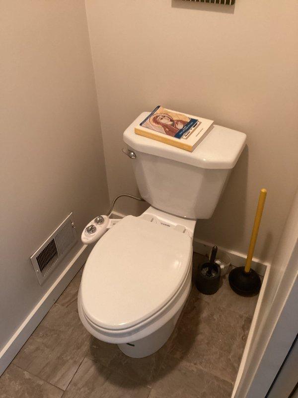 Completed plumbing club inspection of residential bathrooms, identifying and documenting multiple minor drip leaks throughout the fixtures. Photographed conditions of half-bathroom with bidet-equipped toilet and master bathroom with double vanity setup for maintenance records and follow-up recommendations.