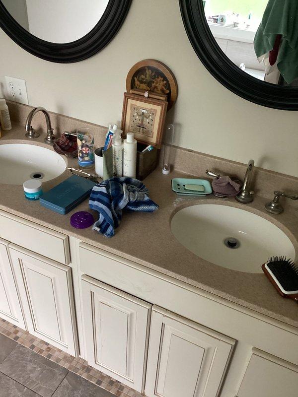 Completed plumbing club inspection of residential bathrooms, identifying and documenting multiple minor drip leaks throughout the fixtures. Photographed conditions of half-bathroom with bidet-equipped toilet and master bathroom with double vanity setup for maintenance records and follow-up recommendations.