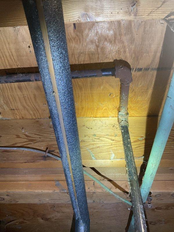 Responded to service call for 15-year-old Bradford White Defender water heater with non-functioning thermometer preventing proper heating and hot water recognition. Addressed slow leak originating from gasket area. Upon inspection, documented existing water damage evidenced by yellow staining on overhead plywood sheathing, indicating previous or ongoing moisture intrusion from the leaking gasket. Assessed condition of water heater connections, copper supply lines, and associated plumbing components in basement mechanical room.