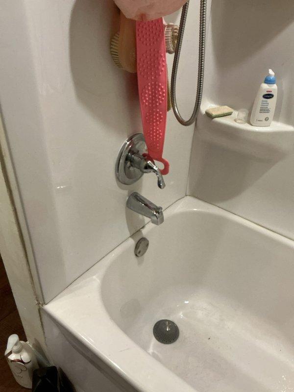 Responded to upstairs shower leak occurring within wall cavity of 40-year-old residence. Performed visual inspection of bathtub/shower combination unit and surrounding fixtures including chrome-plated diverter valve, tub spout, and handheld shower assembly. Documented existing conditions through photographic evidence showing standard fiberglass surround, wall-mounted plumbing fixtures, and accessible components. Assessed potential leak sources behind wall surface affecting only this fixture with no reported damage to other areas of home. Provided diagnostic findings and repair recommendations to address ongoing moisture intrusion issue.
