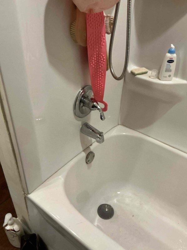 Responded to upstairs shower leak occurring within wall cavity of 40-year-old residence. Performed visual inspection of bathtub/shower combination unit and surrounding fixtures including chrome-plated diverter valve, tub spout, and handheld shower assembly. Documented existing conditions through photographic evidence showing standard fiberglass surround, wall-mounted plumbing fixtures, and accessible components. Assessed potential leak sources behind wall surface affecting only this fixture with no reported damage to other areas of home. Provided diagnostic findings and repair recommendations to address ongoing moisture intrusion issue.