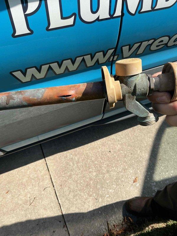 Cut access opening in ceiling to expose concealed plumbing. Located corroded copper hose bib with significant oxidation and patina buildup causing leak. Removed and replaced failed hose bib assembly with brass shut-off valve. Tested new installation for proper operation and verified no active leaks present.
