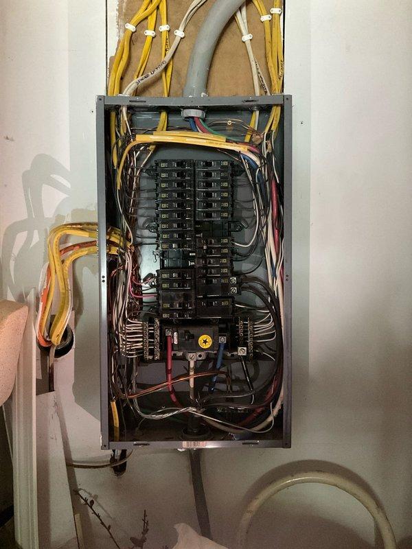 Conducted electrical system assessment and documentation at residential property. Performed comprehensive inspection of main electrical panel, photographing existing configuration including circuit breaker arrangement, wire routing, and service entrance connections. Panel evaluation revealed multiple branch circuits with romex wiring entering through top access point along with main service conduit. Documented current electrical infrastructure for future upgrade planning and code compliance review.