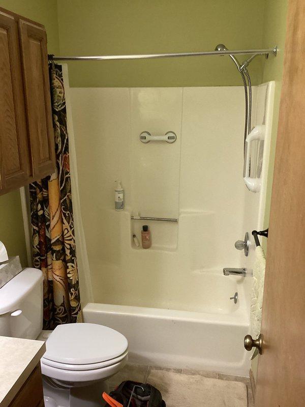 Responded to service call for malfunctioning shower diverter stuck in shower position and broken showerhead. Successfully repaired diverter mechanism to restore proper function between tub spout and showerhead, and replaced damaged handheld showerhead unit with new chrome fixture mounted on existing slide bar assembly.