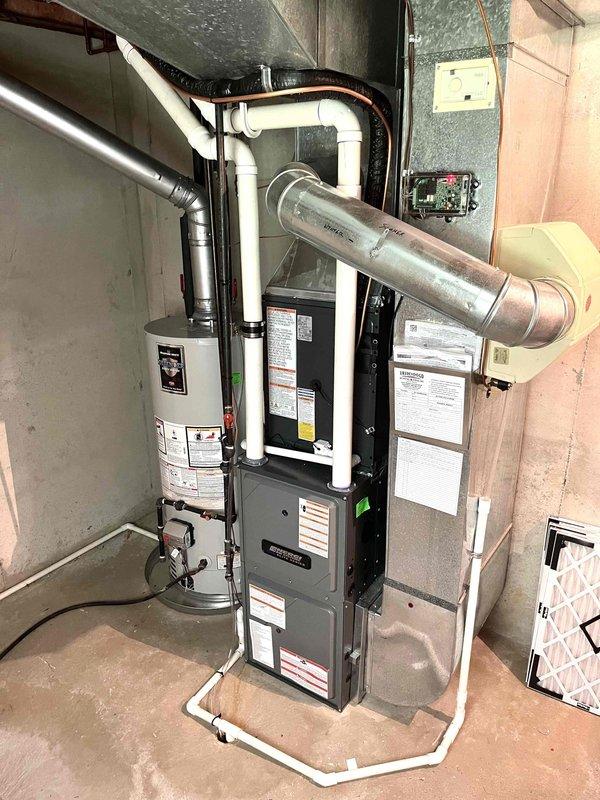Completed full HVAC system replacement including indoor furnace unit and outdoor condensing unit. Installed new furnace in basement utility area with proper venting and ductwork connections, positioned adjacent to existing water heater. Mounted new outdoor condensing unit on concrete pad at exterior corner of residence, installed refrigerant line set with appropriate insulation, secured electrical disconnect box to siding, and completed all refrigerant connections between indoor and outdoor components. System tested and verified operational upon completion.