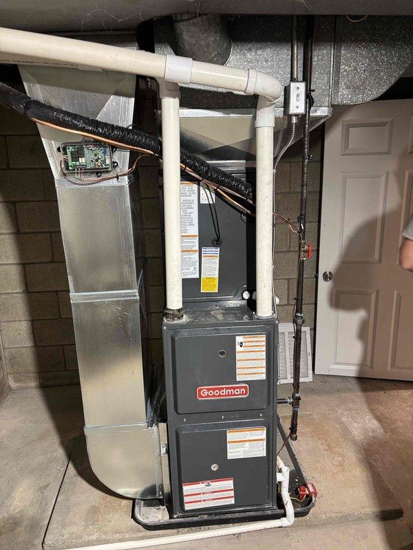Completed add-on air conditioning installation to existing forced-air heating system. Installed Goodman brand outdoor condensing unit on concrete pad with proper refrigerant line sets insulated with black jacketing, established electrical disconnect, and routed PVC condensate drainage along exterior wall. Added indoor evaporator coil cabinet adjacent to existing furnace in basement utility area, connected supply and return ductwork with flexible transitions, and integrated system controls. Tested system operation, verified proper airflow, confirmed refrigerant charge, and ensured all connections meet manufacturer specifications.