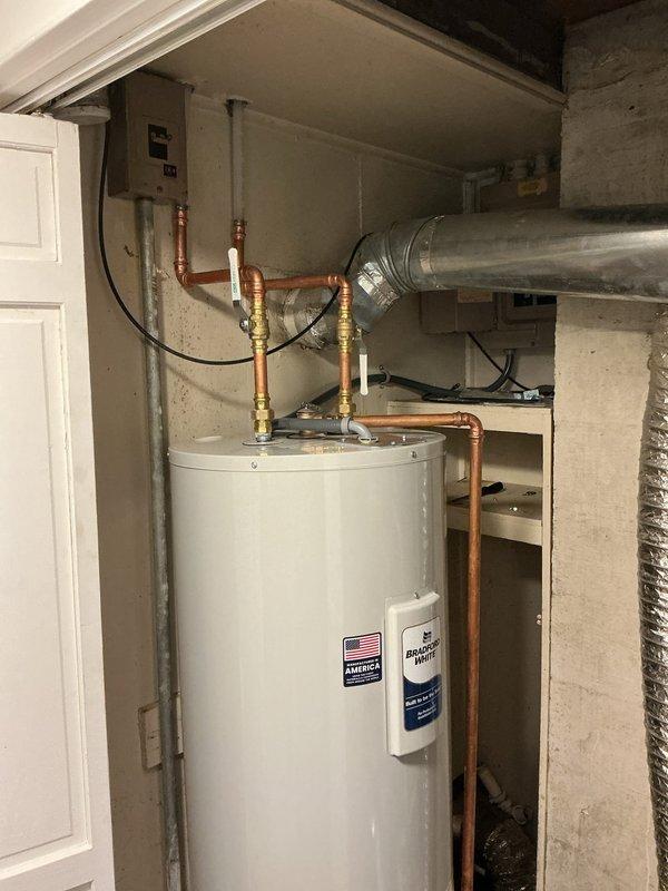 # Water Heater Installation

Successfully installed a 40-gallon tall electric water heater in basement utility room. Completed all plumbing connections with copper piping, brass fittings, and shut-off valves at the unit inlet and outlet. Established proper electrical connections to supply power to the heating elements. Secured water heater in position per manufacturer specifications and local code requirements. Verified all connections for proper seal integrity and tested unit operation. Installation includes integration with existing HVAC ductwork and plumbing infrastructure in the mechanical room space.