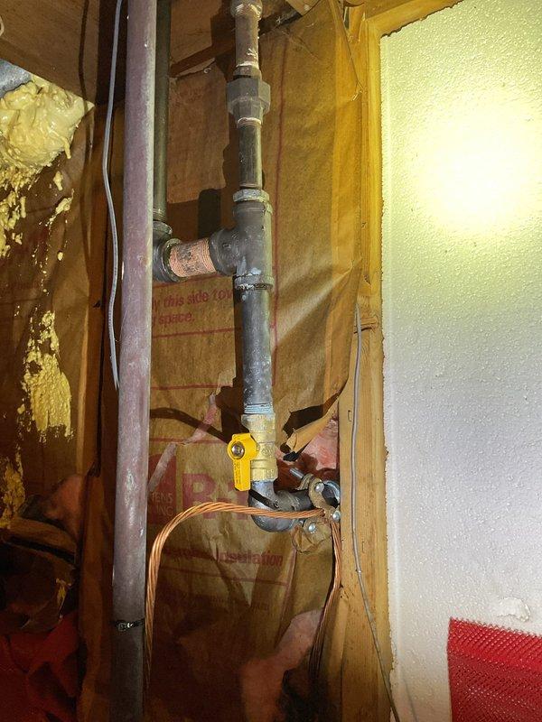 # Gas Repair From Meter Into Home / CWOW

Completed gas line repair from exterior meter to interior distribution system. Replaced damaged galvanized steel piping section within exposed wall cavity, installing new threaded connections and joints to ensure proper gas flow and system integrity. Installed yellow-handled gas shut-off valve at accessible location within wall framing for emergency isolation capability.

Verified exterior meter connections and PVC protective conduit routing along building exterior remained secure and code-compliant. All joints were tested for leaks using approved detection methods. Interior piping was properly secured within wall cavity alongside existing copper lines. Work performed in area with exposed fiberglass insulation and wooden stud framing. System restored to full operational status with proper pressure and no leaks detected.