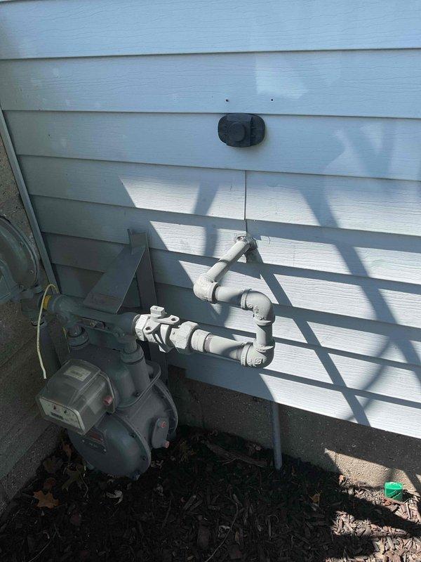 # Gas Repair From Meter Into Home / CWOW

Completed gas line repair from exterior meter to interior distribution system. Replaced damaged galvanized steel piping section within exposed wall cavity, installing new threaded connections and joints to ensure proper gas flow and system integrity. Installed yellow-handled gas shut-off valve at accessible location within wall framing for emergency isolation capability.

Verified exterior meter connections and PVC protective conduit routing along building exterior remained secure and code-compliant. All joints were tested for leaks using approved detection methods. Interior piping was properly secured within wall cavity alongside existing copper lines. Work performed in area with exposed fiberglass insulation and wooden stud framing. System restored to full operational status with proper pressure and no leaks detected.