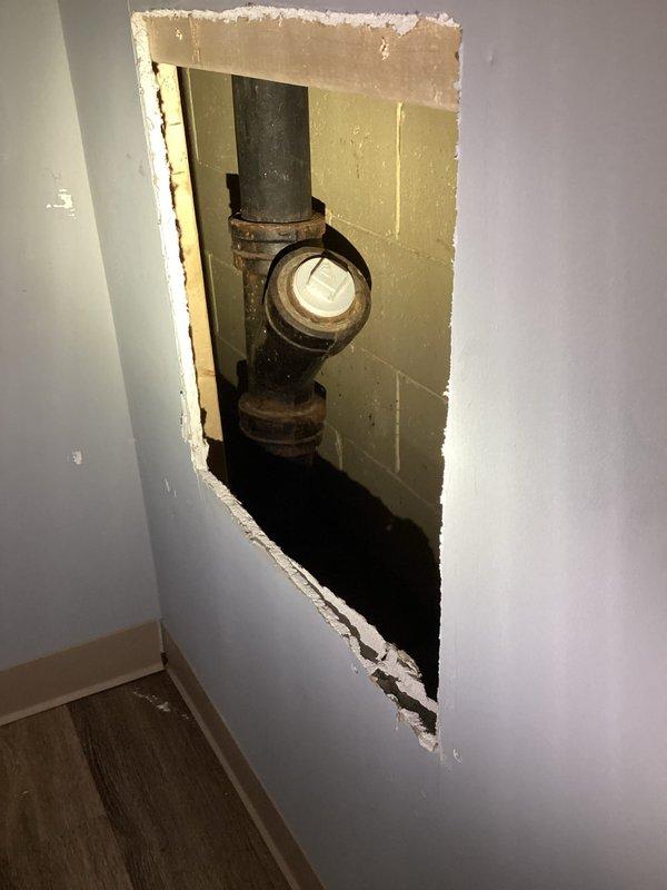 Responded to main drain backup in basement. Accessed cleanout fitting through existing wall opening to address drainage obstruction. Inspected vertical drain waste vent (DWV) system pipe showing signs of age and corrosion. Cleared blockage in main drainage line, restoring proper flow. Verified shower drain functionality and confirmed system operating normally upon completion.