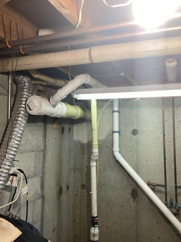 Completed installation of washer pump box system in basement utility area. Installed new white PVC drainage piping with proper vertical and horizontal runs, including necessary elbow joints and wall-mounted brackets for secure attachment to concrete foundation walls. Connected drainage system to black sump pump basin, ensuring proper flow and discharge capabilities. Routed electrical supply using appropriate wiring to power pump system. All plumbing connections tested and verified for proper operation and leak-free performance.