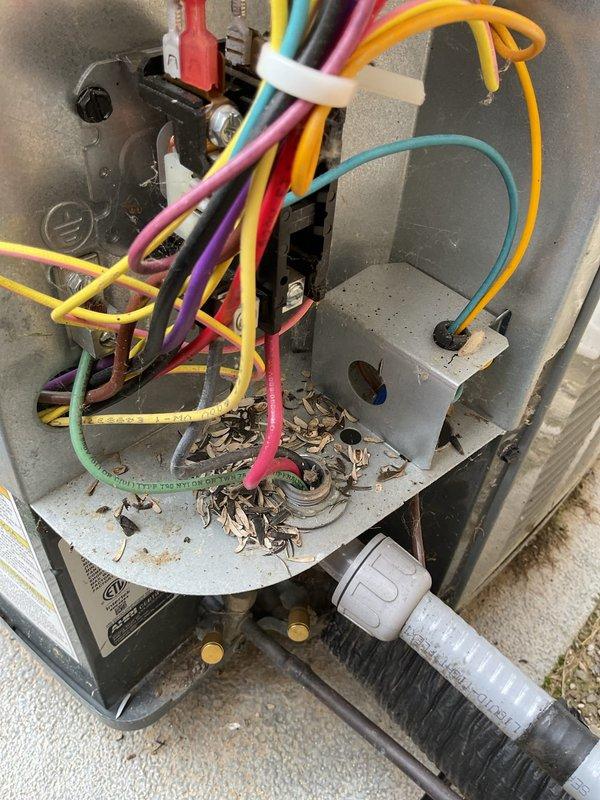 Completed annual cooling maintenance on EnergiAir system with 3-year service agreement. Performed comprehensive inspection of outdoor unit electrical disconnect box and control panel, noting significant weathering and environmental exposure consistent with outdoor installation. Cleaned accumulated debris, dirt, and insect remains from electrical enclosure and control components. Inspected all electrical connections including terminal blocks with multi-circuit wiring configuration, verified proper wire terminations and strain relief fittings on incoming power lines. Examined refrigerant line connections and flexible conduit routing. System operational and ready for cooling season.