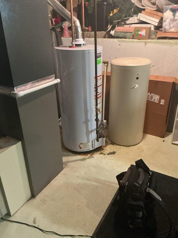 Responded to emergency call for leaking water heater in residential basement. Upon arrival, inspected 15-year-old water heater and identified active leak requiring immediate attention. Documented existing plumbing configuration including copper supply lines, pressure relief valve, and connection points to assess replacement requirements and ensure proper system integration with existing HVAC infrastructure.