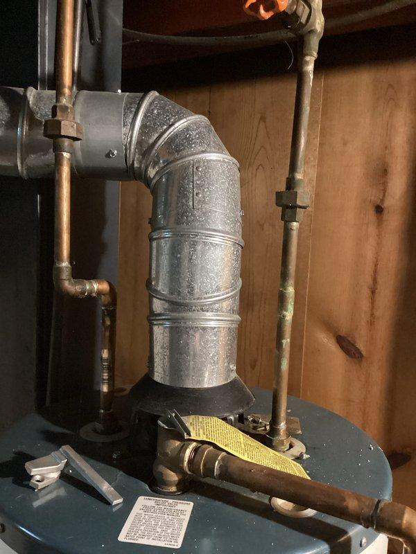 Responded to service call for leaking water heater requiring replacement at residential property. Upon inspection, documented existing water heater installation in attic space, including galvanized vent piping with flexible collar connection, structural mounting configuration, and copper supply lines connected to storage tank. Provided estimate for complete water heater replacement due to unit failure and active leak condition.