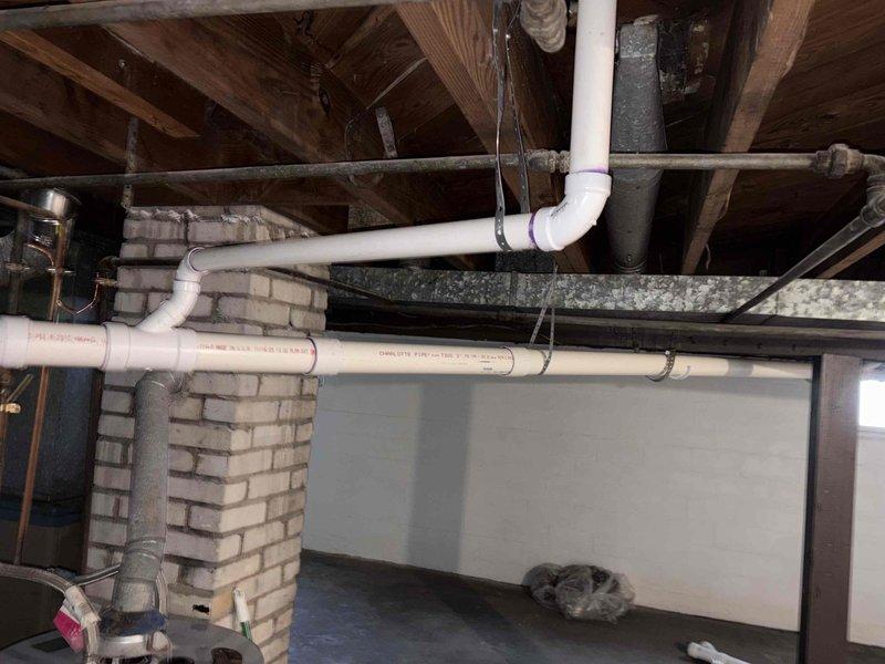 Completed full home drain repipe in basement area, replacing deteriorated drainage systems with new PVC piping throughout the crawl space. Removed compromised ductwork showing extensive surface deterioration and flaking, installed new drainage lines along ceiling joists, and ensured proper routing around existing brick chimney structure and mechanical equipment. All new piping secured to structural beams with appropriate hangers, tested for proper flow and drainage, and workspace cleaned upon completion.