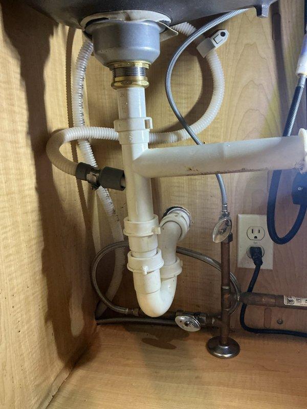 Responded to kitchen sink backup caused by food debris in garbage disposal. Upon inspection, found disposal drain line and P-trap partially obstructed with organic material. Cleared blockage from disposal unit and drain assembly, flushed system to restore proper drainage flow. Tested sink and disposal operation to confirm complete resolution of backup issue.