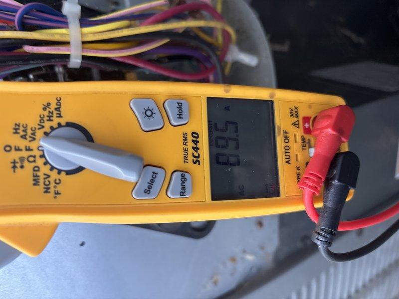 Responded to cooling complaint on 2-3 year old EnergiAir system not maintaining temperature and experiencing power flickering issues. Upon inspection, diagnosed failed dual run capacitor causing reduced cooling capacity and intermittent electrical issues. Removed defective capacitor from outdoor condensing unit and verified failure with multimeter readings showing 6.55 microfarads, significantly below manufacturer specifications. Replaced faulty capacitor with proper OEM-rated component, restored all electrical connections, and verified system operation. Unit now operating within normal parameters with stable amperage draw and proper cooling output.