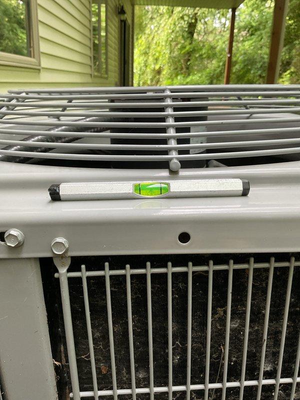 Completed annual cooling maintenance on 2022 Carrier condensing unit. Verified unit level, inspected condenser coil and protective cage, checked mounting hardware and drainage, and documented equipment condition with photos. All components operating within normal parameters.