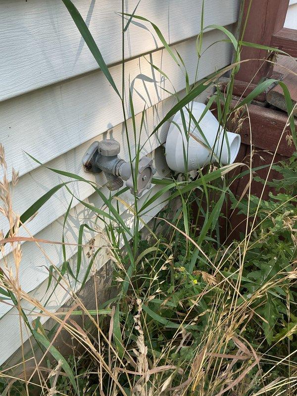 Responded to service call for two inoperable outdoor hose bibs. Upon arrival, inspected both exterior spigot locations and found fixtures mounted on building's exterior siding surrounded by overgrown vegetation. First spigot exhibited metal pipe elbow configuration with corroded fittings, while second location showed weathered mounting hardware. Documented existing conditions including significant algae and mildew growth on siding, indicating prolonged moisture exposure that likely contributed to fixture failure. Cleared vegetation from immediate work areas to access both spigots. Assessed internal valve mechanisms and supply line connections for both units. Completed necessary repairs to restore full functionality to both outdoor faucets, ensuring proper water flow and eliminating leaks. Verified operational status of repaired fixtures before departure.