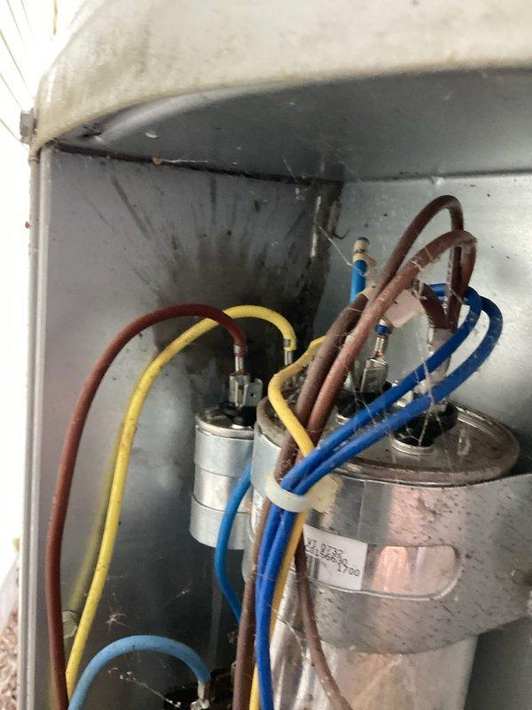 Responded to no cooling complaint with fan operational. Upon inspection, found failed capacitor with visible corrosion and rust on terminals. Capacitor exhibited signs of age-related deterioration with oxidation present at connection points. Replaced defective capacitor with new unit, reconnected all electrical leads, and verified proper wire routing. Tested system operation and confirmed compressor engagement and normal cooling function restored. Unit returned to full operational status.