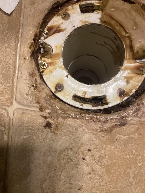 Responded to water leak complaint regarding recently installed toilet. Upon inspection, discovered failed wax ring seal at toilet flange connection causing water seepage onto bathroom floor. Removed toilet to access flange area, which showed significant water staining, corrosion on mounting hardware, and deteriorated seal integrity. Cleaned flange surface, replaced corroded closet bolts, installed new wax ring seal, and properly reset and secured toilet to eliminate leak source.