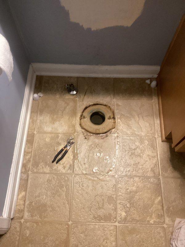 Responded to water leak complaint regarding recently installed toilet. Upon inspection, discovered failed wax ring seal at toilet flange connection causing water seepage onto bathroom floor. Removed toilet to access flange area, which showed significant water staining, corrosion on mounting hardware, and deteriorated seal integrity. Cleaned flange surface, replaced corroded closet bolts, installed new wax ring seal, and properly reset and secured toilet to eliminate leak source.