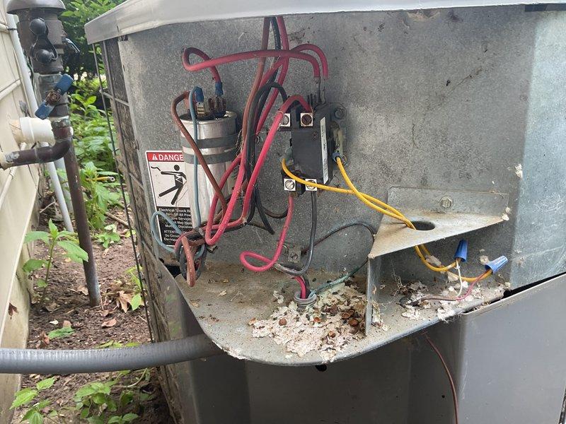 Responded to no cooling complaint on 15-year-old residential air conditioning system. Upon inspection, found outdoor condensing unit operational but with severely clogged condenser coils restricting airflow and preventing adequate heat transfer. Electrical components showed signs of weathering with disorganized wiring but contactor and capacitor appeared functional. Cleaned condenser coils to remove heavy accumulation of dirt, dust, and debris. Verified proper system operation and adequate cooling performance restored. Recommended ongoing maintenance to prevent future efficiency loss.