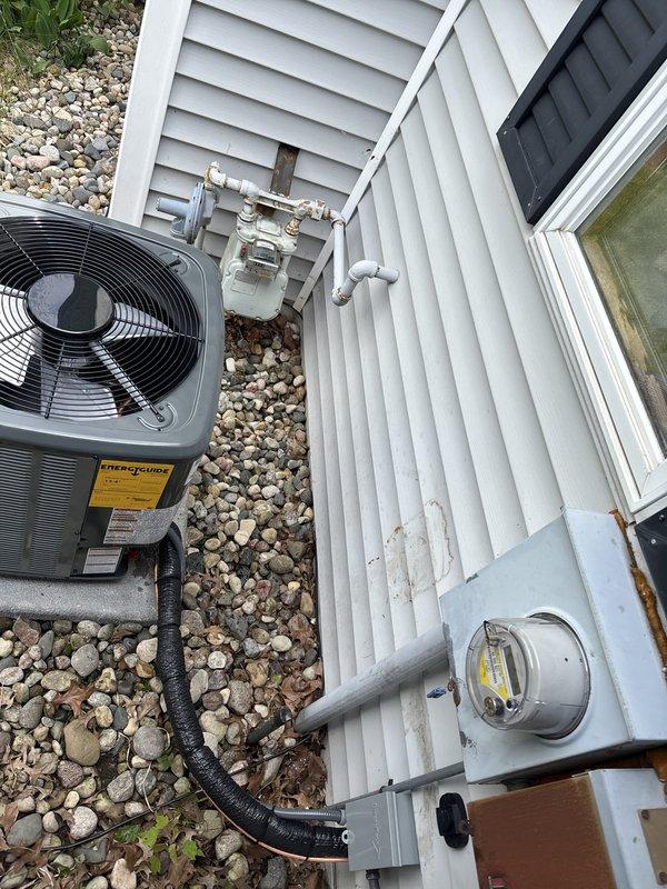 Completed full HVAC system installation including new furnace and air conditioning unit. Installed EnergySource brand condenser unit on exterior pad with proper clearances from building structure, established condensate drainage line routing through landscaping area, and mounted associated utility connections to exterior wall. Interior installation included furnace placement, PVC condensate drain piping to floor drain, and completion of all necessary electrical and gas connections to bring system fully operational.