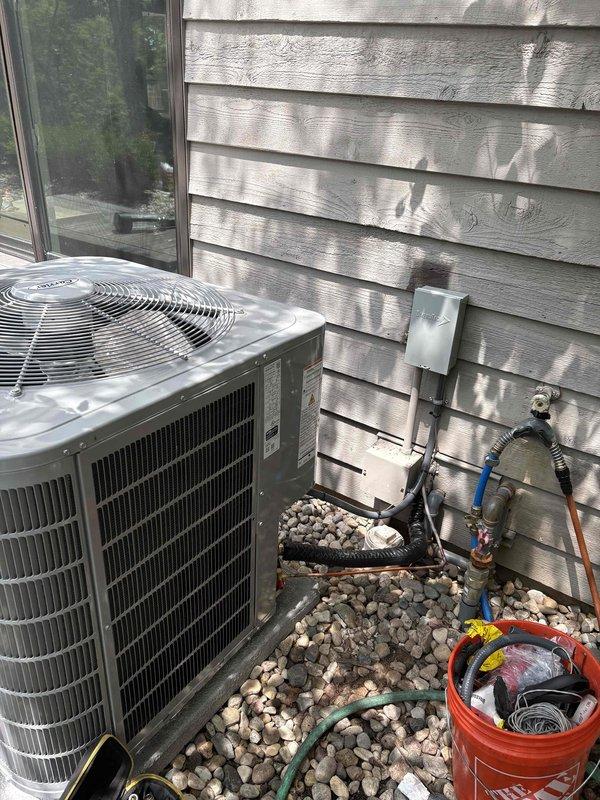 Completed full HVAC system installation including one furnace unit, two air conditioning condensers, and two whole-home humidifiers. Both Carrier AC units were positioned on concrete pads with gravel beds for proper drainage and mounted against exterior siding with appropriate clearances. Installed electrical disconnects, refrigerant line sets with copper piping, service valve assemblies with manifold gauges, and proper conduit routing for each outdoor unit. Connected PVC condensate drain lines and verified all electrical connections to code. System startup procedures performed on all equipment with refrigerant pressures checked and confirmed within manufacturer specifications. All components operational and installation completed per scope of work.