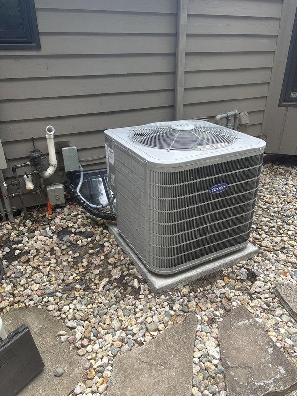 Completed full HVAC system installation including one furnace unit, two air conditioning condensers, and two whole-home humidifiers. Both Carrier AC units were positioned on concrete pads with gravel beds for proper drainage and mounted against exterior siding with appropriate clearances. Installed electrical disconnects, refrigerant line sets with copper piping, service valve assemblies with manifold gauges, and proper conduit routing for each outdoor unit. Connected PVC condensate drain lines and verified all electrical connections to code. System startup procedures performed on all equipment with refrigerant pressures checked and confirmed within manufacturer specifications. All components operational and installation completed per scope of work.