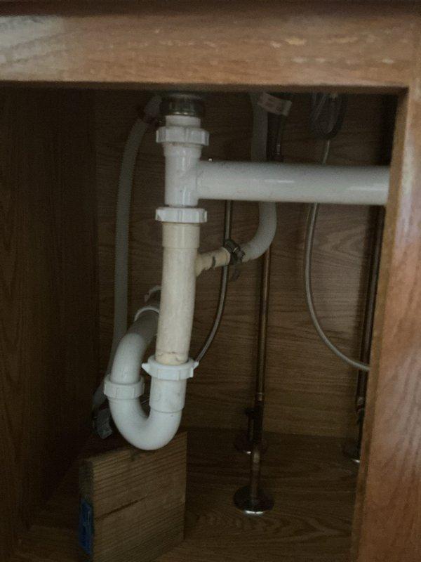 Completed kitchen sink replacement in 32-year-old residence. Installed new double-basin stainless steel sink with single-handle faucet in brushed nickel finish and separate spray nozzace assembly. Configured standard PVC drain assembly with P-trap beneath sink, ensuring proper drainage and code-compliant installation. All plumbing connections tested and verified leak-free upon completion.