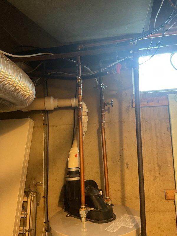 Provided estimate for replacement of 15-year-old Bradford White water heater located in unfinished basement utility area. Assessed existing plumbing configuration including copper supply lines, PVC venting system, and current equipment placement among exposed framing and mechanical systems. Documented site conditions and equipment specifications with photographs for proposal preparation.