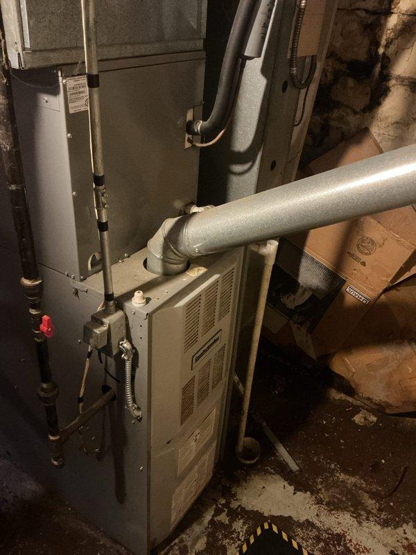 Responded to no-power complaint on 16-year-old furnace following electrical power surge caused by downed power line from tree fall. Upon arrival, confirmed blown fuse had already been replaced but unit remained without power. Performed diagnostic testing on electrical system and determined power surge had caused damage beyond the protective fuse, resulting in complete loss of power to the heating unit. Documented equipment condition and electrical failure with photos of outdoor condenser unit and indoor furnace installation. Customer advised of findings and repair options needed to restore system operation.