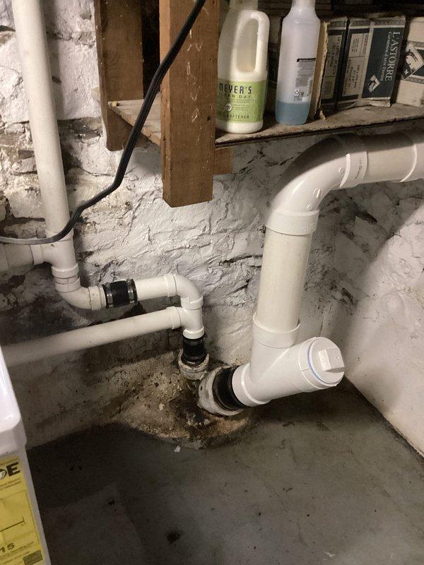 Replaced kitchen sink and washing machine drain lines from subfloor to main stack, installing new tee fitting to catch both fixtures with 2" PVC piping routed to kitchen sink for improved drainage and clog prevention. Removed and replaced 12 linear feet of deteriorated 4" cast iron piping with new PVC pipe, fittings, and proper support hangers. Cleared obstruction from pop-up assembly in upstairs bathroom sink to restore proper drainage function.