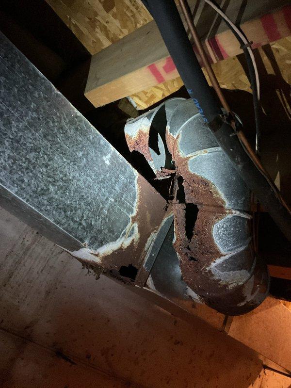 Responded to service call for non-operational 26-year-old Comfortmaker air conditioning unit suspected of requiring R22 refrigerant recharge. Upon inspection, documented significant deterioration of attic ductwork including severely compromised insulation wrapping, extensive rust corrosion on exposed metal surfaces, and structural integrity concerns with visible gaps and openings in damaged sections. Prepared estimate for system repair considerations prior to scheduled replacement installation.