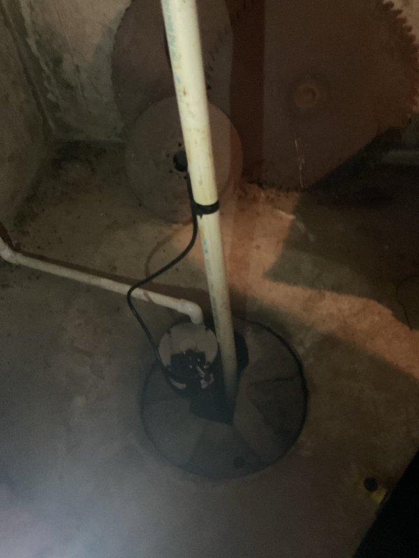 Responded to sump pump failure in basement utility area. Removed existing non-functional sump pump unit and assessed drainage system configuration. Installed new sump pump with appropriate discharge capacity for residential application. Reconfigured plumbing connections including vertical PVC discharge piping to ensure proper drainage flow and code compliance. Installed new basin cover/lid to seal basement floor opening, preventing debris entry and reducing moisture exposure. Secured all piping with appropriate fasteners and verified electrical connections for pump operation. Tested system operation and confirmed proper cycling and discharge functionality.
