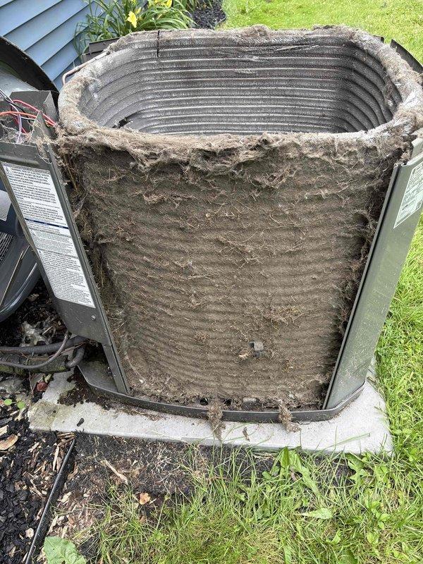 # CP-Cooling Problem

Responded to no-cooling complaint on 6-year-old Trane air conditioning system. Upon inspection, found condenser unit with severely restricted airflow due to heavy accumulation of dirt, debris, and lint completely covering exterior condenser coil surfaces. Outdoor ambient temperature measured at 92°F. Condenser coil buildup was extensive and matted, significantly reducing heat transfer capacity and system efficiency. Documented unit condition with photographs showing compromised coil surfaces and overall neglect of routine maintenance. System components were operational but unable to achieve adequate cooling due to restricted condenser coil preventing proper heat rejection. Recommended thorough condenser coil cleaning to restore proper airflow and system performance.
