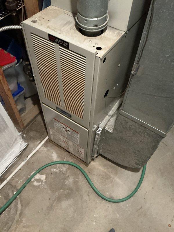 Completed furnace and air conditioning replacement estimate for aging HVAC system. Assessed existing 16-year-old furnace and AC unit located in basement mechanical room, documented equipment condition showing visible wear and dust accumulation, evaluated ductwork configuration including flexible aluminum ducting and humidifier attachment, and identified inadequate cooling performance to upper level as primary concern requiring system upgrade.