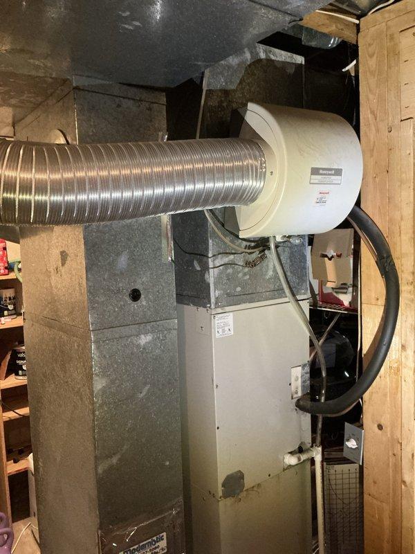 Completed furnace and air conditioning replacement estimate for aging HVAC system. Assessed existing 16-year-old furnace and AC unit located in basement mechanical room, documented equipment condition showing visible wear and dust accumulation, evaluated ductwork configuration including flexible aluminum ducting and humidifier attachment, and identified inadequate cooling performance to upper level as primary concern requiring system upgrade.