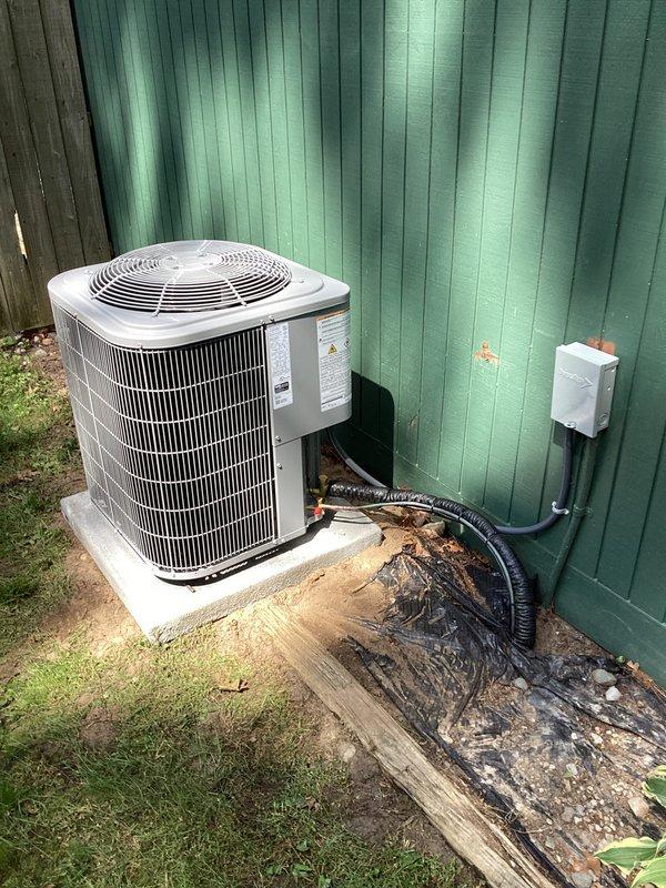 Completed full HVAC system installation including indoor Carrier furnace unit and outdoor condensing unit. Indoor furnace was installed in utility closet with proper ductwork connections, PVC condensate drain lines, refrigerant line set, and electrical wiring. Outdoor condenser was positioned on concrete pad against building exterior with electrical disconnect box mounted to wall and conduit properly secured. All components tested and verified operational upon completion.