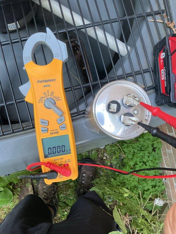 Responded to no cooling complaint on 9-year-old EnergiAir system affecting entire residence. Upon inspection, discovered bird nest constructed inside outdoor unit with debris obstructing electrical components and wiring. Removed nest material including twigs, grass, and insulation from around contactor, capacitor, and wire connections. Tested capacitor with clamp meter, verified electrical connections, and confirmed system operational. Unit restored to normal cooling operation.