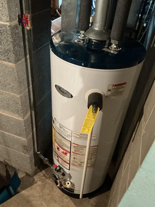 Responded to service call for 19-year-old water heater with no hot water production and pilot light failure. Upon inspection, successfully relit pilot light and verified proper burner ignition, as evidenced by blue flame visible through viewing window. Tested unit operation and confirmed restoration of hot water supply to residence.