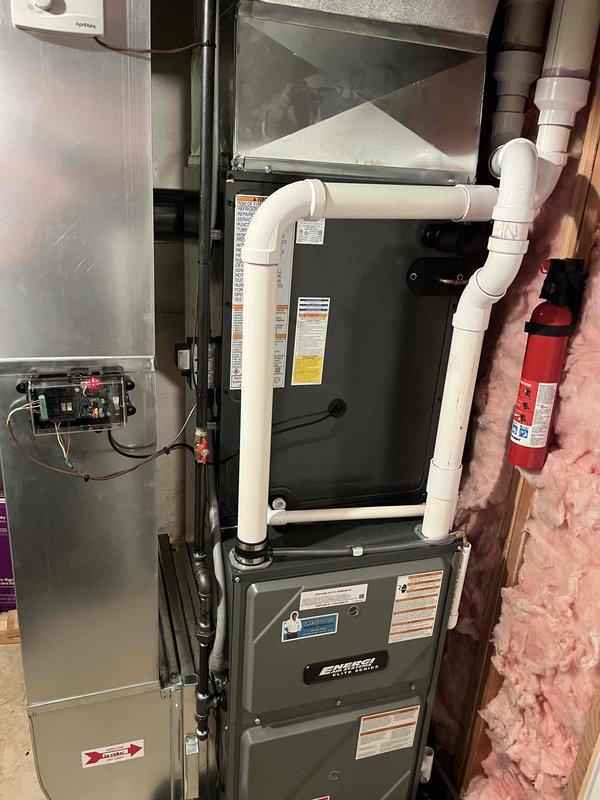 Completed full HVAC system replacement including installation of new furnace unit and outdoor condensing unit. Indoor equipment installed in basement utility area with proper electrical connections, control panel integration, and PVC condensate drainage piping. Outdoor condenser positioned against exterior wall on existing pad with refrigerant line connections completed. All electrical connections verified, system charged to manufacturer specifications, and full operational testing performed to confirm proper heating and cooling functionality. Equipment installation meets code requirements with appropriate clearances maintained for service access and airflow.