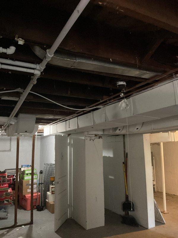 Completed on-site assessment for installation of 15-foot gas line run to accommodate dryer hookup in 1948-built home with no existing gas line infrastructure. Evaluated unfinished basement area with exposed floor joists, concrete block foundation walls, and existing utility systems including PVC plumbing, ductwork, and electrical conduit to determine optimal routing path for new gas line installation. Documented current conditions and structural layout to provide accurate material requirements and labor estimate for proposed gas line extension project.